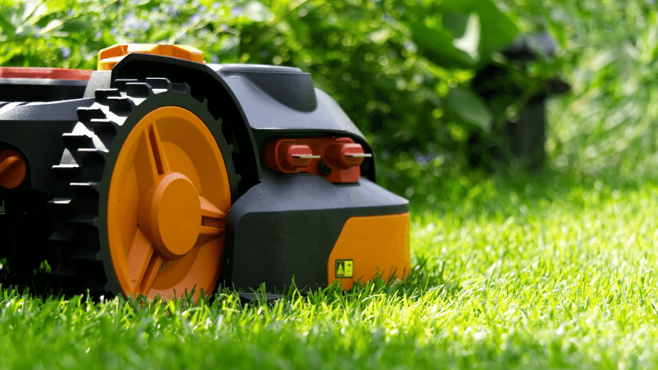 Robot grasmaaier in actie op een groen gazon.